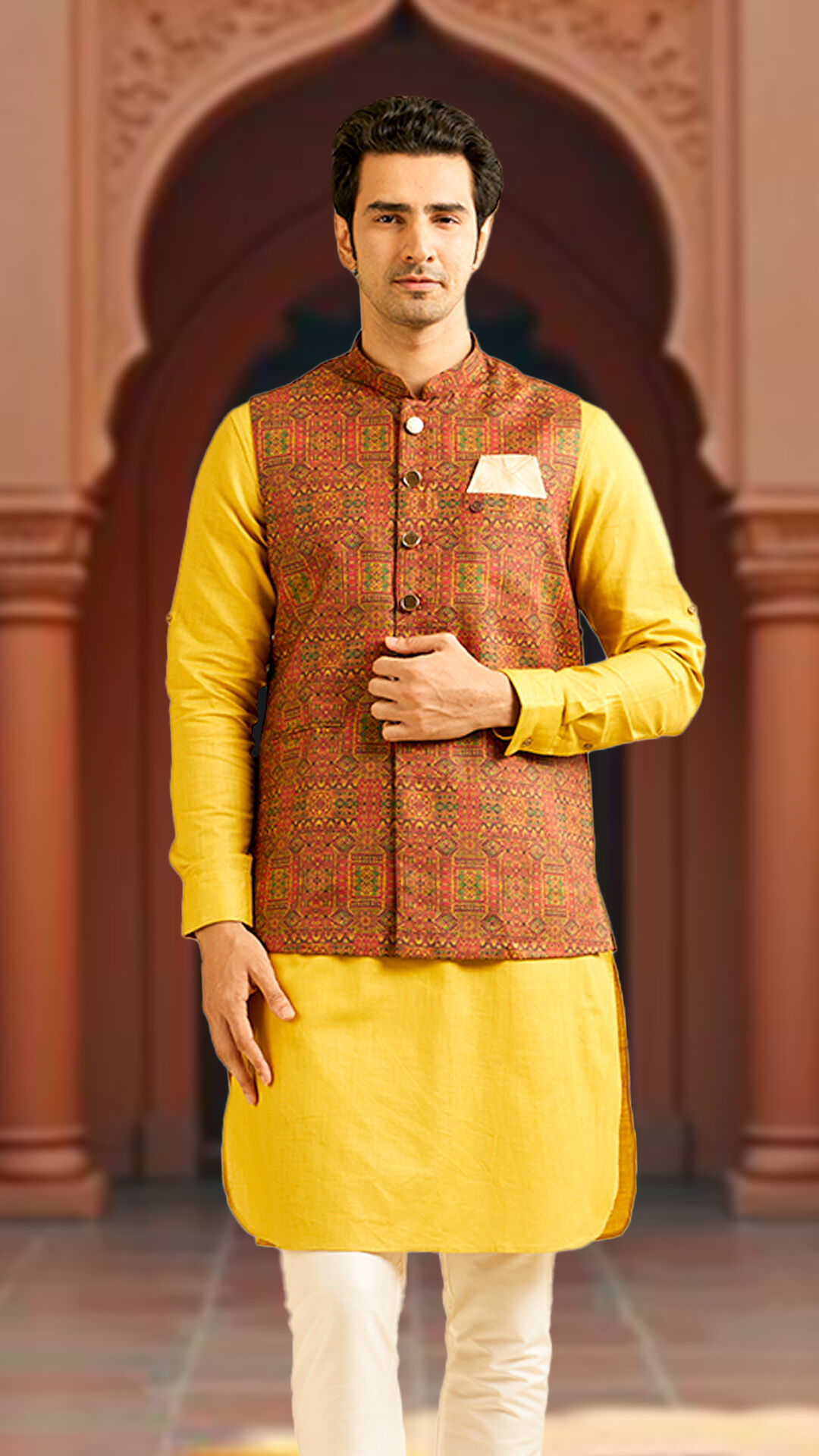 A man in yellow kurta with printed jacket